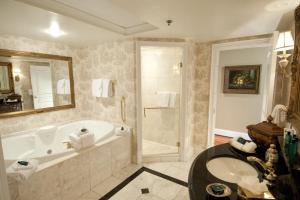 a bathroom with a tub and a sink and a shower at Market Pavilion Hotel in Charleston