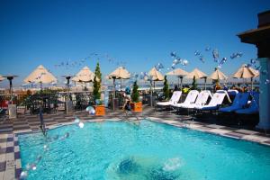 a swimming pool with chairs and umbrellas at a hotel at Market Pavilion Hotel in Charleston