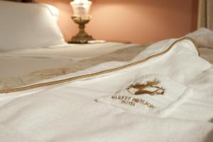 a white blanket on a bed with a hotel appliance patch at Market Pavilion Hotel in Charleston