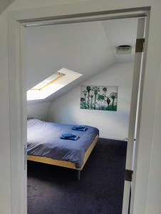 Dormitorio pequeño con cama en el ático en De Oude Katsei, en Gingelom
