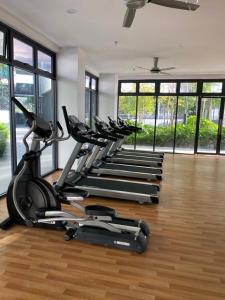 a row of exercise bikes in a gym with windows at Airport KLIA Guest House (1 bedroom & 1 toilet) in Sepang