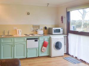 a kitchen with a washing machine and a microwave at Chalet 3 - Uk30304 in Tore