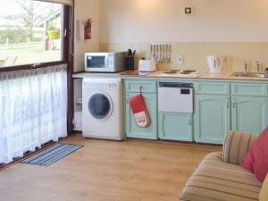 a kitchen with a washing machine and a microwave at Chalet 3 - Uk30304 in Tore