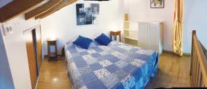 a bedroom with a blue and white bed with blue pillows at GITE LA FREYDIERE in La Bégude-de-Mazenc +12 photos