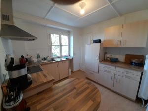 uma cozinha com armários brancos e uma mesa de madeira em Unterm Tulpenbaum em Müllheim