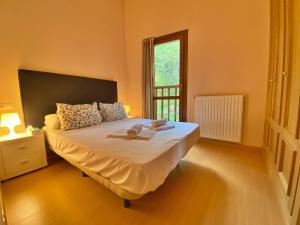 een slaapkamer met een groot wit bed en een raam bij Pleta de Soldeu Ático hasta 4 personas. in Canillo