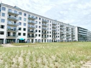 ein großes weißes Gebäude mit einem Feld davor in der Unterkunft Ferienwohnung "Jolle" in Binz