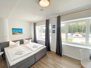 ein Schlafzimmer mit einem Bett und einem großen Fenster in der Unterkunft Ferienwohnung "Jolle" in Binz