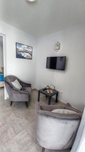 a living room with a couch and a tv at Appartement au cœur du village d'HellBourg in Salazie