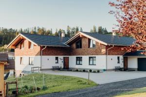 ein Haus mit einer Einfahrt davor in der Unterkunft Allgäu-Chalets-Niso in Waltenhofen