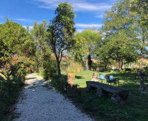 a park with a bench and people sitting in the grass at Meraviglia in Vetralla