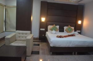 a hotel room with a bed and a chair at The Himalaya Park in Bhilai