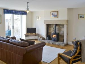 a living room with a couch and a fireplace at Dollys Cottage in Ovingham