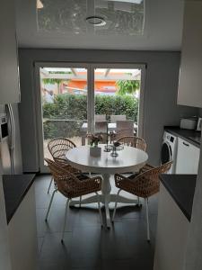 a kitchen with a white table and chairs and a window at Altes Gewölbe mit Sauna und Whirlpool im Außenbereich in Elsterheide