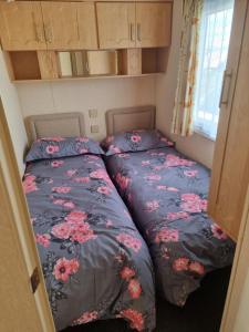 two beds in a small room in a caravan at Meadow Lakes 56 in Chapel Saint Leonards