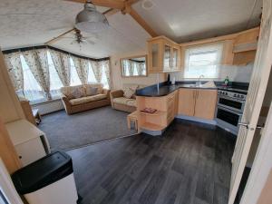 a kitchen and living room in a tiny house at Meadow Lakes 56 in Chapel Saint Leonards
