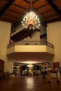 a chandelier in a lobby with a horse in a room at Hacienda Bajamar in Sonorabampo