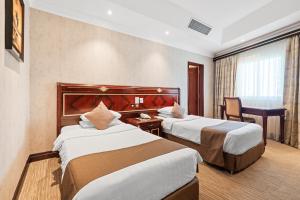 Llit o llits en una habitació de Chairmen Hotel