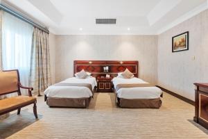 Llit o llits en una habitació de Chairmen Hotel