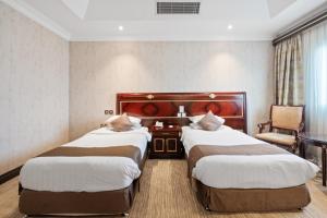 Llit o llits en una habitació de Chairmen Hotel