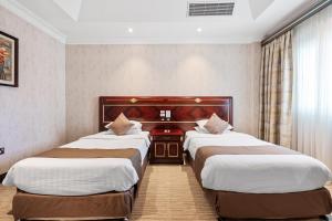 Llit o llits en una habitació de Chairmen Hotel