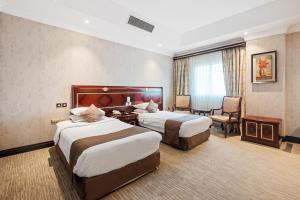Llit o llits en una habitació de Chairmen Hotel