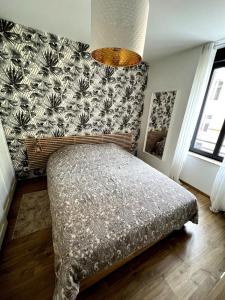 Chambre cosy, proche centre-ville et gare في كولمار: غرفة نوم مع سرير وورق جدران