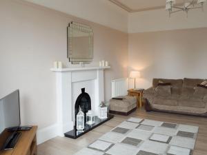 a living room with a couch and a fireplace at Charlotte Street in Ayr