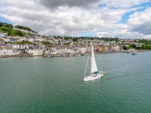 a sailboat in the water in front of a city at Waterfront House in Dartmouth