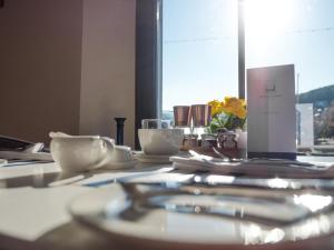 a table with plates and utensils and a window at Waterfront House in Dartmouth