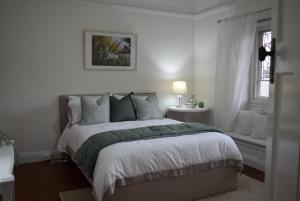a bedroom with a large bed with white walls at Fitzroy House - Federation charm near town centre in Cowra