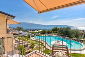 Vom Balkon eines Hotels genießen Sie Poolblick. in der Unterkunft La Chioma di Berenice Garda Residence in Toscolano-Maderno