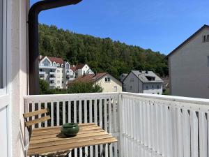 zielony wazon siedzący na drewnianym stole na balkonie w obiekcie SAD150 - Moderne Monteurwohnungen in Schwandorf mit Balkon w mieście Schwandorf