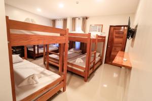 a room with three bunk beds in a room at Josefina's Tourist Inn in Busuanga