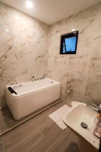 a white bathroom with a tub and a sink at Josefina's Tourist Inn in Busuanga