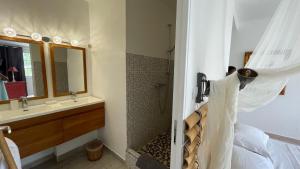 ein Bad mit einem Bett, einer Dusche und einem Waschbecken in der Unterkunft Le M Hotel Marie Galante in Beauregard