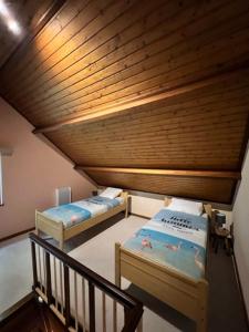 two beds in a room with a wooden ceiling at Panoramic Bungalow Sint Gillis-Waas in Sint-Gillis-Waas
