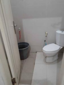 a bathroom with a toilet and a bucket at EXPRESS O 91662 Kost Rumah Kaca in Mirue