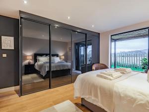 a bedroom with a bed and a large window at The Barn At Whitefields in Walcot