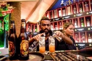 een man en een vrouw aan een bar met drankjes bij Sizzle Sports Club in Kandy