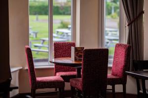 uma mesa e cadeiras num quarto com uma janela em Highfield Hotel em Middlesbrough