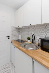 a kitchen with a sink and a microwave at Micro Apartment near Fort Mokotów in Warsaw