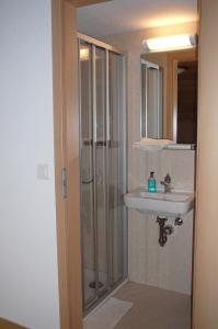 ein Bad mit einem Waschbecken und einer Dusche in der Unterkunft Gästehaus Schäfli in Intschi