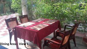 a table with four chairs and a red table cloth at Sithara Homestay Fort Cochin in Cochin