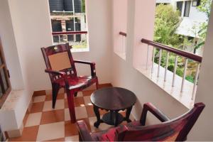 um quarto com duas cadeiras, uma mesa e uma janela em Sithara Homestay Fort Cochin em Cochin