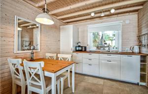 eine Küche mit einem Holztisch und weißen Schränken in der Unterkunft 2 Bedroom Amazing Home In Kolczewo in Kołczewo