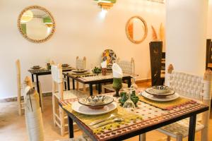 a dining room with a table and chairs and mirrors at Riad Amra in Marrakesh