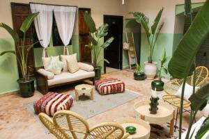 a living room with a couch and chairs and plants at Riad Amra in Marrakesh