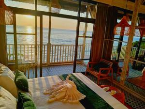 a room with a bed with a view of the ocean at The Sagara Penida Nusa Penida in Nusa Penida