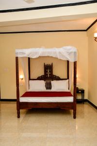 a bed with a canopy in a room at Minara Miwili - Forodhani Park in Zanzibar City